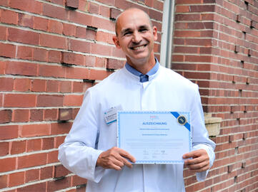 Dr. Martin Schnell, Leitender Oberarzt der Klinik für Allgemein- und Viszeralchirurgie am Klinikum Singen, mit der Auszeichnung der Arbeitsgemeinschaft deutscher Darmkrebszentren