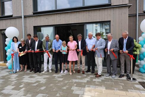 Damit das neue Eltern-Kind-Haus zum Erfolg wurde, haben viele mitgeholfen – wie man beim symbolischen Banddurchschneiden deutlich erkennen konnte. Bild: Andrea Jagode